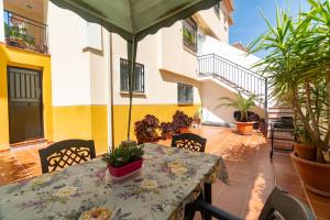 a patio with a table and chairs and an umbrella at Bonita casa en Granada+PARKING EN EL CENTRO+WIFI in Ambroz