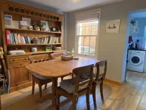 a dining room with a wooden table and chairs at Green Cottages in Sittingbourne