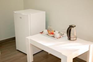 a white table next to a white refrigerator at Standard room in Morningside guesthouse - 2090 in Bulawayo