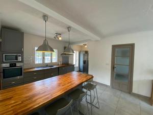 W pokoju znajduje się kuchnia z drewnianym blatem. w obiekcie Très grande Villa pour 1 famille ou plusieurs... w mieście Valbonne