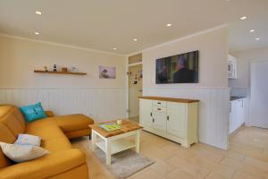 ein Wohnzimmer mit einem Sofa und einem Tisch in der Unterkunft Villa Marina - Gigantischer Meerblick in Wangerooge