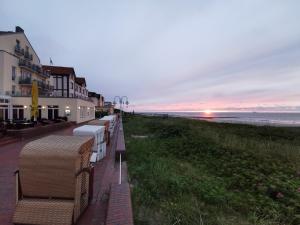 萬格羅格的住宿－Villa Marina - Gigantischer Meerblick，日落时分海滩旁的一排长椅