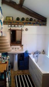 ein Badezimmer mit einer Badewanne und einem Waschbecken in der Unterkunft Grande et belle maison. Jardin. Lac des Sapins. 