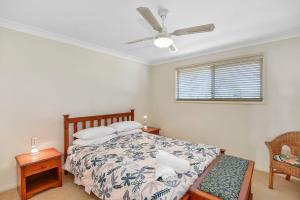 1 dormitorio con 1 cama y ventilador de techo en Bluewater at Mannering Park, en Mannering Park