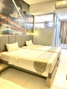 ein Schlafzimmer mit zwei Betten und einem großen Fenster in der Unterkunft OS Hotel Tanjung Uncang in Sagulung