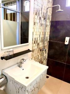 y baño con lavabo y ducha. en OS Hotel Tanjung Uncang, en Sagulung