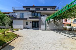 a large white house with a brick driveway at Villa Ida in Rovinj