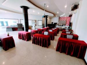 ein Zimmer mit roten Tischen und Stühlen in einem Restaurant in der Unterkunft OS Hotel Tanjung Uncang in Sagulung