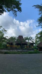 un edificio con palmeras delante en Khayangan Resort Yogyakarta, en Balong