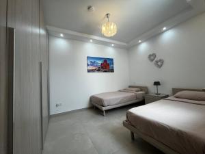 斯利馬的住宿－Stunning penthouse, 2 bedroom, heart of Sliema，一间卧室配有两张床和吊灯。