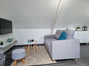 een woonkamer met een bank en een tafel bij Le P'tit Cosy in Lorient