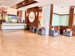 eine Lobby mit 2 Stühlen und einer Rezeption in der Unterkunft OS Hotel Tanjung Uncang in Sagulung