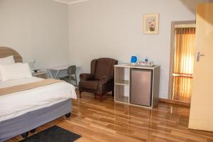um quarto de hotel com uma cama e uma cadeira em Neat one bedroom in Morningside guesthouse - 2091 em Bulawayo
