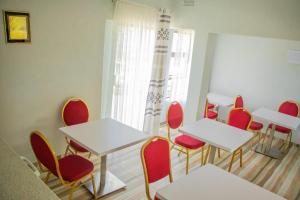 um quarto com mesas e cadeiras e uma janela em Neat one bedroom in Morningside guesthouse - 2091 em Bulawayo