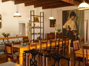 a dining room with a large painting on the wall at Klaarstroom Hotel in Klaarstroom