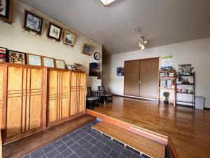 a large room with wooden cabinets and a wooden floor at Hachibosi in Makinohara