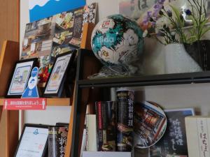 a book shelf with a globe and books at Hachibosi in Makinohara