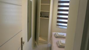 ein Bad mit einem Schrank mit Handtüchern und einem Fenster in der Unterkunft Summer House by the Sea - 40 m to the beach in Side