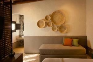 um quarto com uma cama e alguns cestos na parede em Borgo delle Pietre em Porto Empedocle