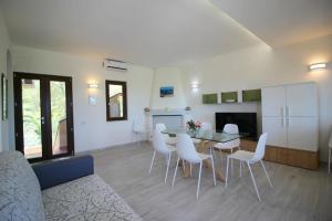 - un salon avec une table et des chaises blanches dans l'établissement Case vacanza Baiazzurra, à Monte Nai