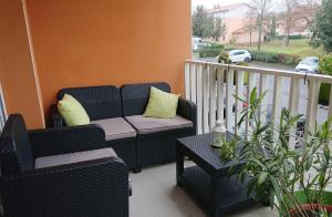 een veranda met 2 stoelen en een bank op een balkon bij Res au calme et arboree in Dax