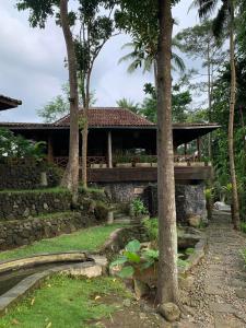 una casa en medio de un jardín con árboles en Khayangan Resort Yogyakarta, en Balong