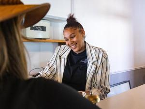 Una donna in piedi in una cucina che parla con una donna di Klaarstroom Hotel a Klaarstroom