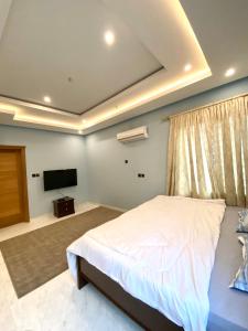 a bedroom with a bed and a flat screen tv at Sydney’s villa in Accra