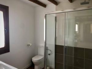 a bathroom with a toilet and a glass shower at A CASA DO ACIVRO in Outes