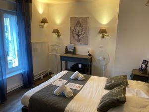 a bedroom with a bed with two pillows and a desk at Hotel L'Ecrin 88 Vosges in Grandvillers