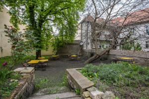 un patio con mesas, sillas y un árbol en New Stylish 3 Suites Bedrooms Apt in Mala Strana - N2nd en Praga