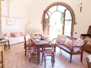 a living room with a table and a couch at Relais Casale Il Poggetto - OLIVO 2 by Zoom In Earth in Cecina