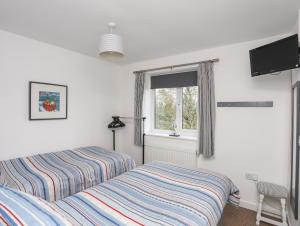 a bedroom with a bed and a window at 2 Y Bont in Pentraeth