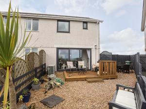 a backyard with a deck and a house at 2 Y Bont in Pentraeth