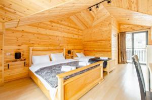 sypialnia z 2 łóżkami w drewnianym domku w obiekcie Aronia Kazbegi w mieście Stepancminda