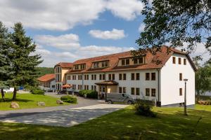 a large white building with a red roof at Riverdam Boutique Hotel in Ilmenau