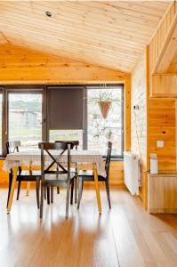 a dining room with a table and chairs in a room at Aronia Kazbegi in Stepantsminda