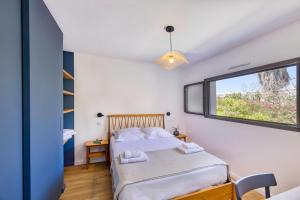 1 dormitorio con cama y ventana en Superbe T2 neuf haut de gamme, climatisé, parking gratuit, 2eme ligne balcon, jardin en Carnon-Plage