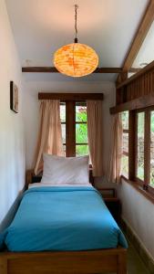 Un dormitorio con una cama azul y una lámpara. en Khayangan Resort Yogyakarta, en Balong