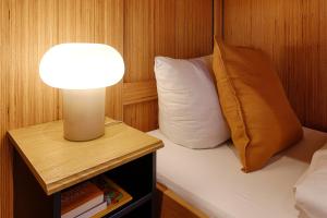 a lamp on a nightstand next to a bed with a pillow at Radapartment -Terrasse & Grill - by homekeepers in Iphofen