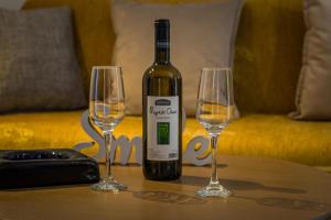 una botella de vino y dos copas de vino en una mesa en Loutraki Beach & Casino Condo en Loutraki