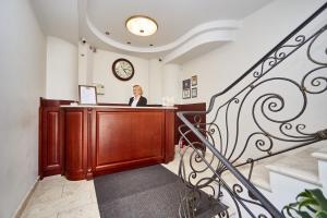 a woman sitting at a desk in a waiting room at Royal Street Hotel in Odesa