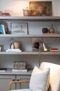 una sala de estar con una silla y estanterías con libros en Farriers Cottage-Tranquil Haven, Central Location! en Hexham