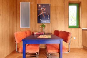a dining room with a blue table and orange chairs at Radapartment -Terrasse & Grill - by homekeepers in Iphofen