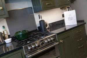a kitchen with a stove with a pot on it at Farriers Cottage-Tranquil Haven, Central Location! in Hexham