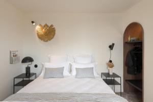 a bedroom with a large bed with white sheets and pillows at Hôtel Le Prieuré in Paray-le-Monial