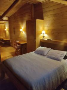 a bedroom with a bed and a desk and a table at Les cabanes de pellier in Charcier