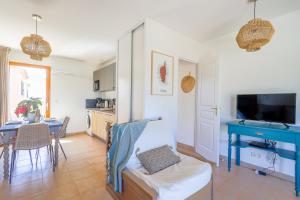 sala de estar con mesa azul y cocina en Capra Scorsa - Appt vue mer et piscine partagée, en Belgodère