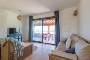 sala de estar con sofá y mesa en Capra Scorsa - Appt vue mer et piscine partagée, en Belgodère