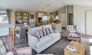 a living room with a couch and a kitchen at Par Sands Coastal Holiday park in Par